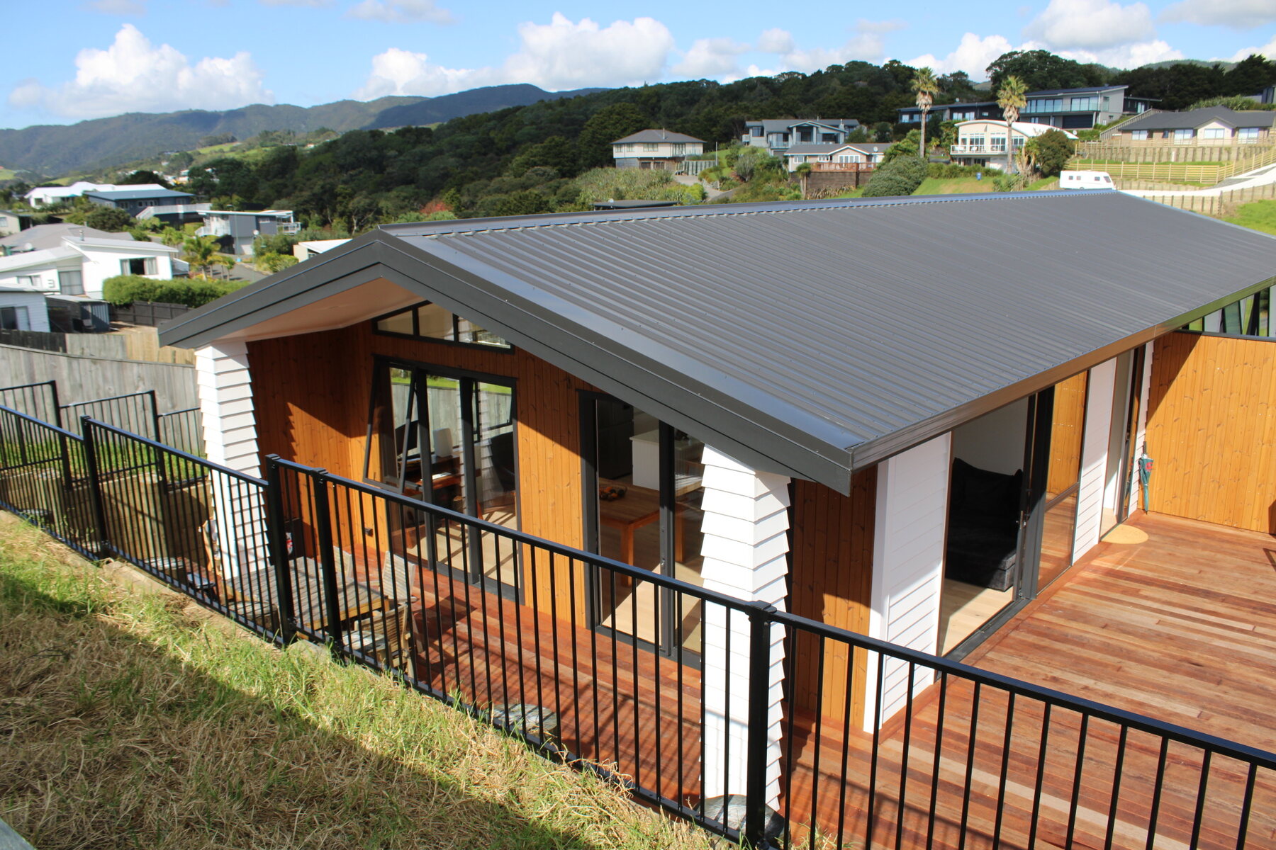 Exterior of the new Langs Beach holiday home with timber deck and coastal hillside outlook