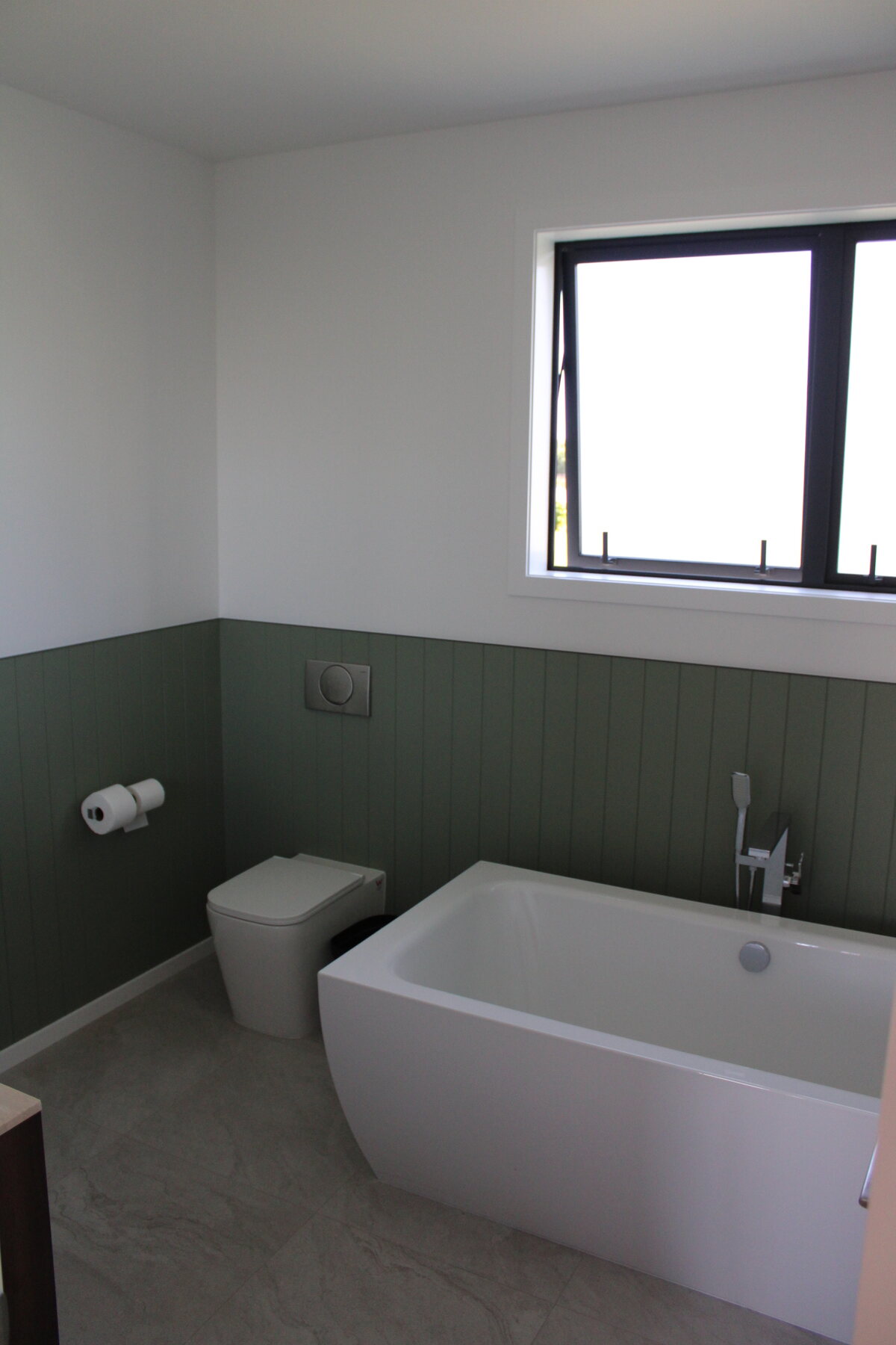 Bathroom with bath, toilet, basin, and black-framed window