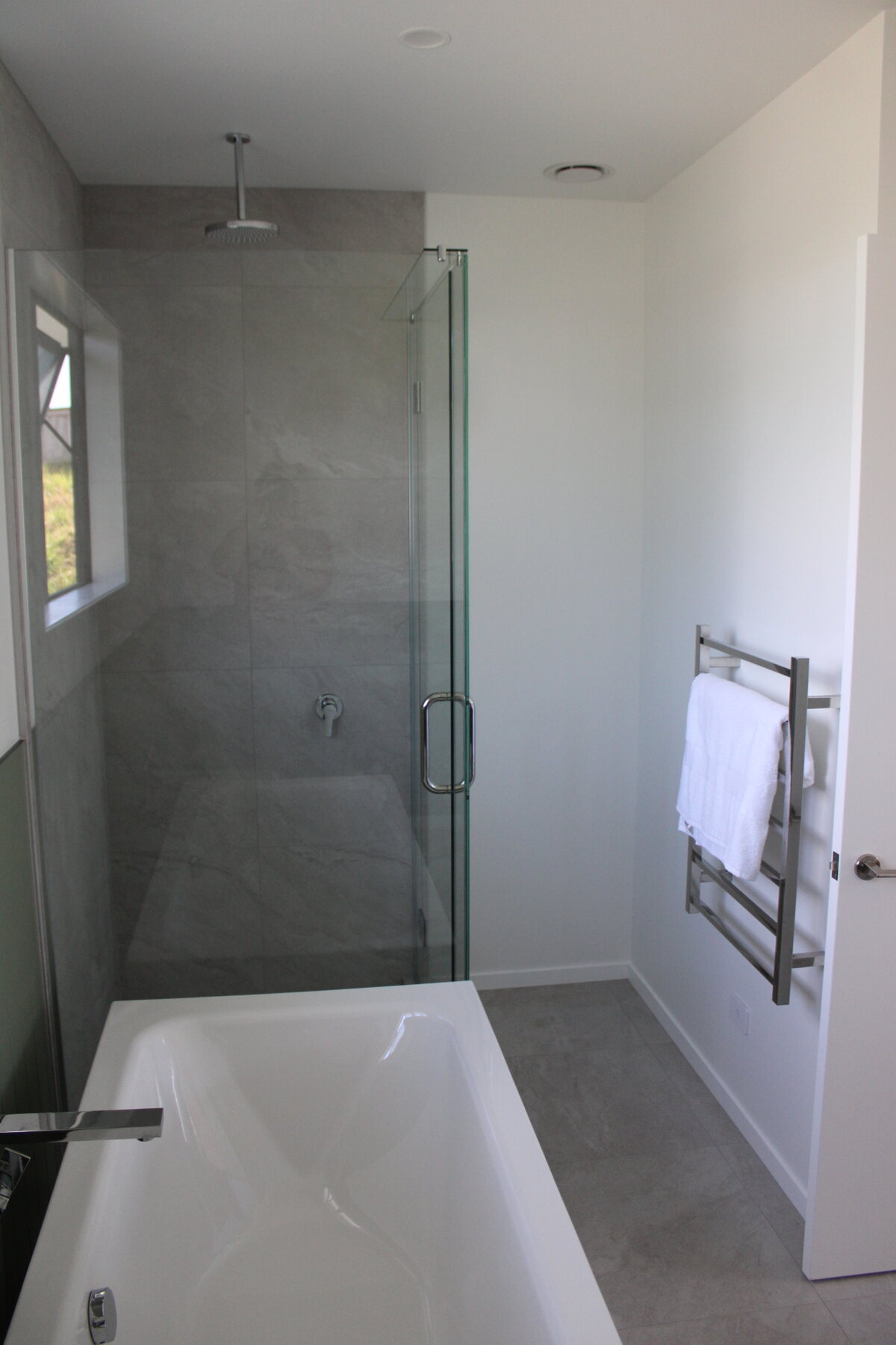 Bathroom shower with bath and towel rail